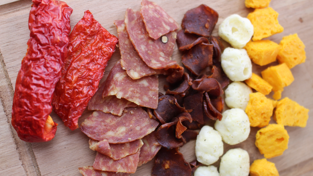 Meat, salami, bacon and cheese snacks in a charcuterie board.